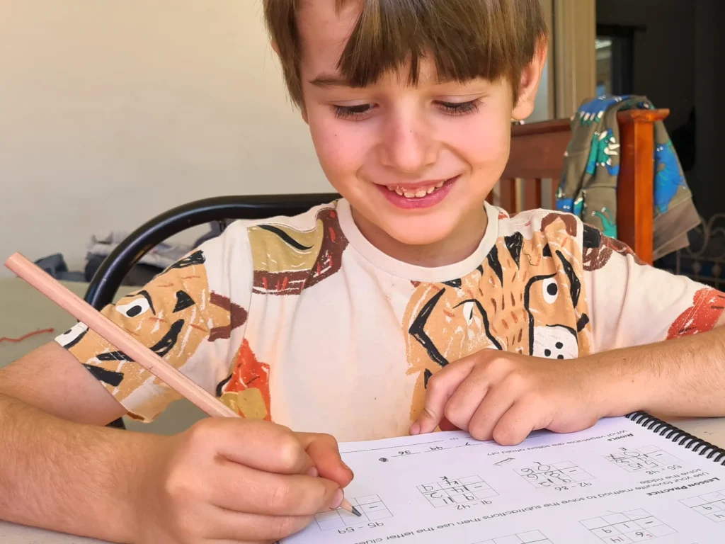 Boy completing a page of Milestone Maths